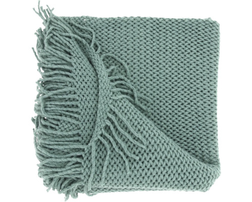 Plaid vert en maille épaisse avec franges décoratives.