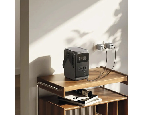 Station de charge portable sur une étagère, branchée sur une prise murale avec deux câbles USB.