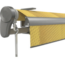 Gelenkarmmarkise mit gelb gemustertem Stoff und Kurbelstange an einer grauen Metallkassette.