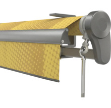 Vue détaillée d'un store à bras articulés avec toile jaune à motifs, caisson métallique gris et œillet pour manivelle.