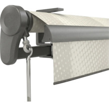 Gros-plan d'un mécanisme de store gris foncé avec un œillet de manivelle et une toile blanche à motif de points.