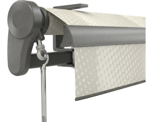 Gros-plan d'un mécanisme de store gris foncé avec un œillet de manivelle et une toile blanche à motif de points.