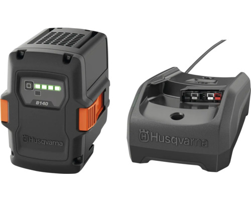 Husqvarna Akku B140 und Ladegerät. Der schwarze Akku besitzt orangefarbene Entriegelungstasten und eine Ladestandsanzeige. Husqvarna Logo.