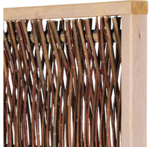 Gros plan sur une clôture occultante composée de branches naturelles tressées dans un cadre en bois clair.