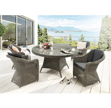 Salon de jardin en résine tressée avec table ronde en verre et quatre fauteuils, coussins inclus, sur une terrasse lumineuse.