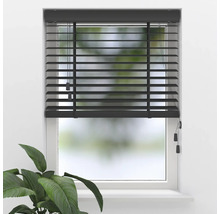 Store vénitien en bois anthracite sur une fenêtre avec cadre blanc et une plante au premier plan.