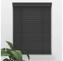 Store vénitien en bois gris foncé avec de larges lamelles, monté dans un cadre de fenêtre, avec une plante verte au premier plan.