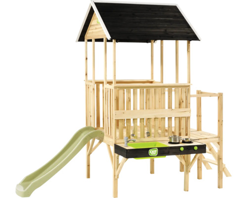 EXIT TOYS Spielhaus aus Holz auf Stelzen mit schwarzem Dach, grüner Rutsche und integrierter Spielküche. EXIT TOYS Logo.