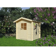 Petit abri de jardin en bois clair de style chalet avec toit à deux pans et porte simple vitrée dans un jardin lumineux avec des lilas en fleurs.