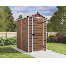 Un abri de jardin avec toit à deux pentes et une porte simple sur une base en béton dans un jardin avec pelouse et fleurs.