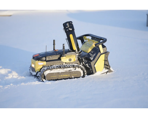 Autonomer Schneefräsen-Roboter von Yarbo mit Kettenantrieb und Auswurfschacht beim Schneeräumen im Außenbereich.