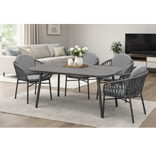 Salle à manger moderne : table rectangulaire grise et quatre chaises en corde tressée avec coussins dans un salon lumineux.