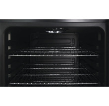 Intérieur d un four avec deux grilles métalliques et un éclairage intérieur allumé au plafond.