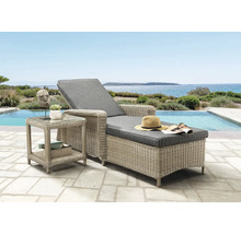 Chaise longue en resine tressee avec coussins gris et table d appoint sur une terrasse au bord d une piscine avec vue sur la mer.