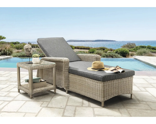 Chaise longue en resine tressee avec coussins gris et table d appoint sur une terrasse au bord d une piscine avec vue sur la mer.