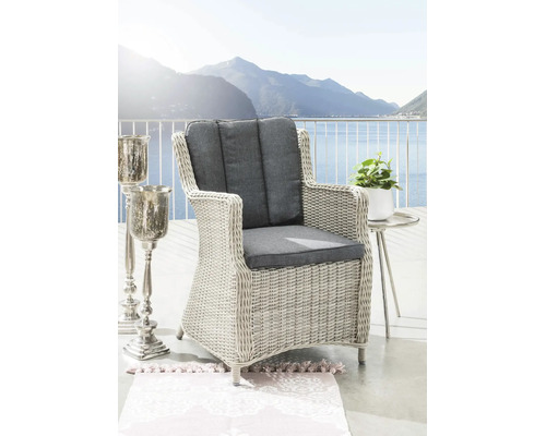 Fauteuil de jardin en résine tressée gris clair avec coussins anthracite sur une terrasse avec vue sur le lac.