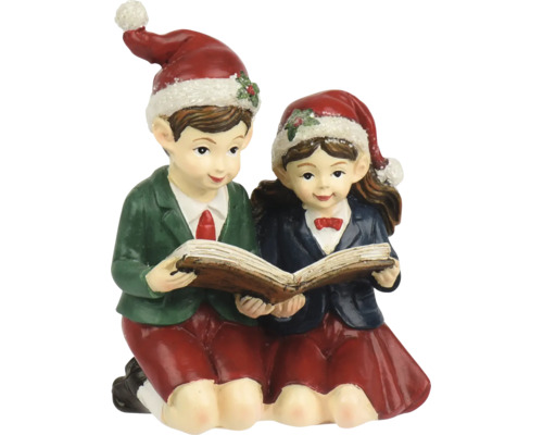 Figurine de Noël garçon et fille lisant un livre ensemble, portant tous deux des bonnets de Noël.