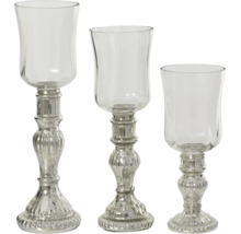 Lot de trois bougeoirs décoratifs en verre de différentes hauteurs avec pied argenté et partie supérieure transparente.
