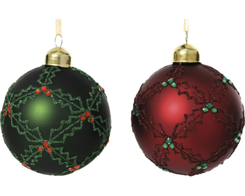 Deux boules de Noël avec décor de houx pailleté, une vert foncé avec baies rouges et une rouge foncé avec baies vertes.