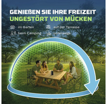 Tragbares Mückenschutzgerät auf einem Tisch im Garten, mit symbolischer Schutzzone über einer Gruppe von vier Personen beim Picknick.