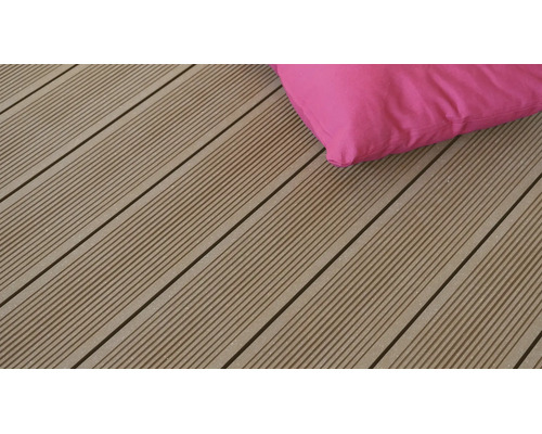 Lames de terrasse en WPC avec surface finement rainurée et un coussin rose.