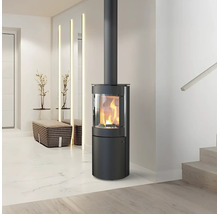 Poêle à bois cylindrique moderne en acier noir avec un feu allumé dans un salon lumineux et minimaliste.