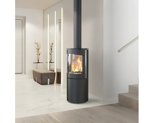 Poêle à bois cylindrique moderne en acier noir avec un feu allumé dans un salon lumineux et minimaliste.