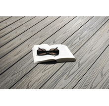 Lames de terrasse aspect bois avec un livre ouvert et des lunettes de soleil.