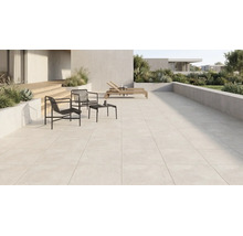 Grousszügeg modern Terrass mat helle Buedemfliesen, schwaarze Metallsesselen, Bäistelltisch, Holzleien a beplanzte Betonskübelen.