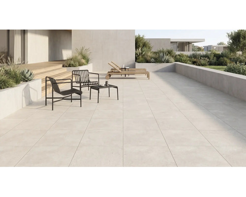 Grousszügeg modern Terrass mat helle Buedemfliesen, schwaarze Metallsesselen, Bäistelltisch, Holzleien a beplanzte Betonskübelen.