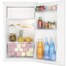 Réfrigérateur blanc ouvert avec compartiment congélateur, rempli de fruits, légumes, bocaux et bouteilles sur des clayettes en verre.