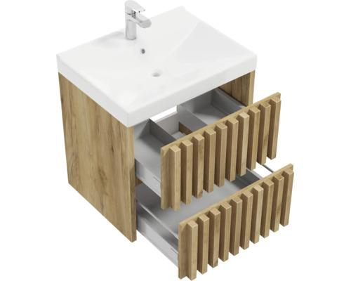 Meuble sous-vasque aspect bois avec deux tiroirs ouverts au design à lamelles et vasque blanche avec robinet.