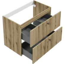 Meuble sous-vasque aspect bois avec deux tiroirs ouverts, façades à rainures verticales et boutons noirs.