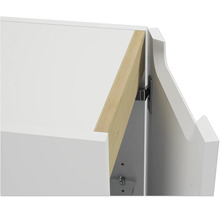 Vue détaillée d'une charnière de meuble sur une armoire blanche avec élément en bois.