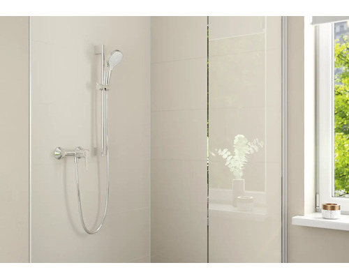 Modernes Duschset mit Handbrause, Brausestange und Einhebelmischer in einem hellen Badezimmer mit Fliesen und Glaswand.