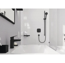 Salle de bains moderne avec lavabo blanc, robinetterie noire et système de douche noir sur carrelage blanc.