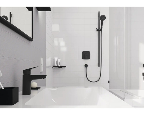 Salle de bains moderne avec lavabo blanc, robinetterie noire et système de douche noir sur carrelage blanc.