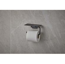 Porte-papier toilette hansgrohe noir mat avec tablette, monté sur un mur à l'aspect pierre naturelle.