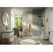 Salle de bains moderne avec meuble blanc, robinetterie noire, miroir rond lumineux, douche à l'italienne et WC suspendu.
