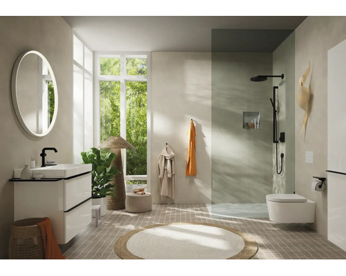 Salle de bains moderne avec meuble blanc, robinetterie noire, miroir rond lumineux, douche à l'italienne et WC suspendu.