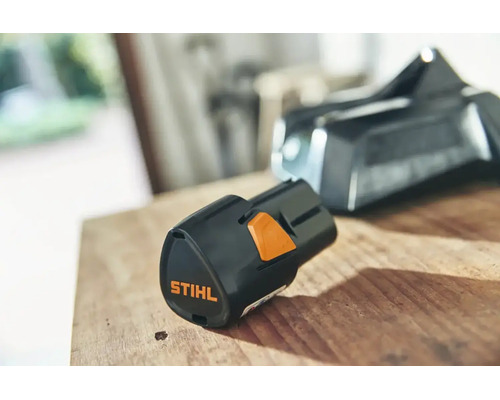 Batterie lithium-ion Stihl AS 2 pour le système AS sur une surface en bois.