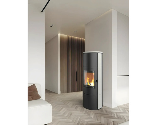 Moderner zylindrischer Kaminofen mit brennendem Feuer in einem hellen Wohnzimmer mit Fischgrätparkett und Holzlamellenwand.