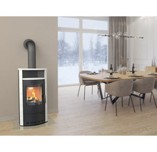 Moderner Kaminofen in Schwarz mit weißer Steinverkleidung in einem hellen Esszimmer mit Blick auf eine Schneelandschaft.
