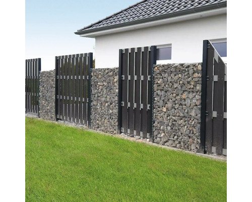 Clôture de jardin moderne composée de gabions avec des pierres grises et des brise-vue verticaux sombres sur une pelouse.