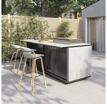 Moderne Außenküche mit Marmoroptik, Spüle, Grill und drei Barhockern auf einer hellen Terrasse vor einem Holzzaun.