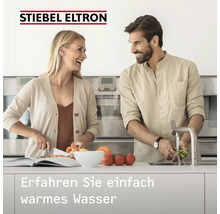 Stiebel Eltron Logo. Couple dans une cuisine moderne et lumineuse lavant et coupant des légumes. Texte: Découvrez simplement l'eau chaude.
