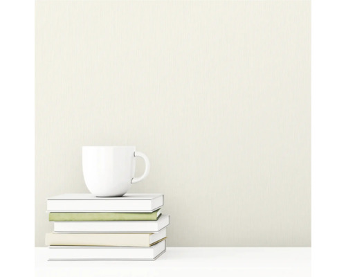 Strukturéiert Tapéit mat engem vertikale Linne-Muster. Am Virdergrond e Stapel Bicher an eng Taass.
