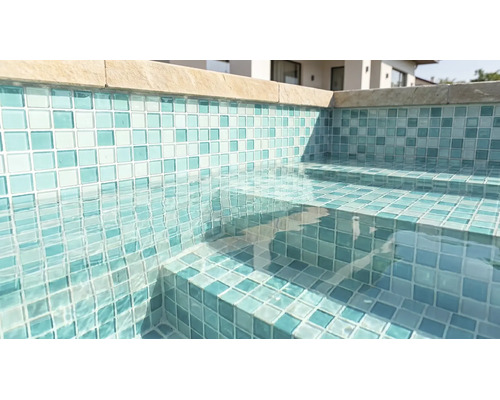 Piscine avec mosaïque sur les parois et les marches, eau claire et margelles.