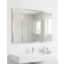 Miroir de salle de bain rectangulaire avec bords biseautés au-dessus d'un lavabo blanc avec robinet et accessoires de salle de bain.