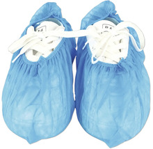 Surchaussures jetables bleues en plastique sur des baskets blanches.
